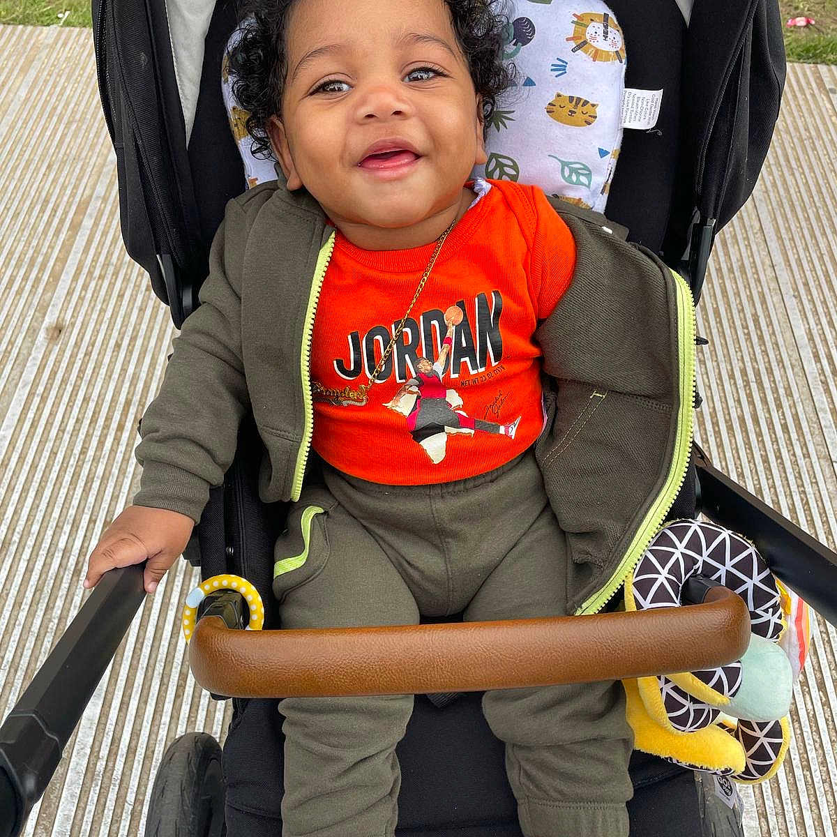 Brayden is registered to the contest to win money with this photo: baby, blackhair, bodypart, clothing, coat, face, hair, happy, head, hosiery, jacket, pants, person, photography, portrait, sitting, smile, sock, stroller, t_shirt