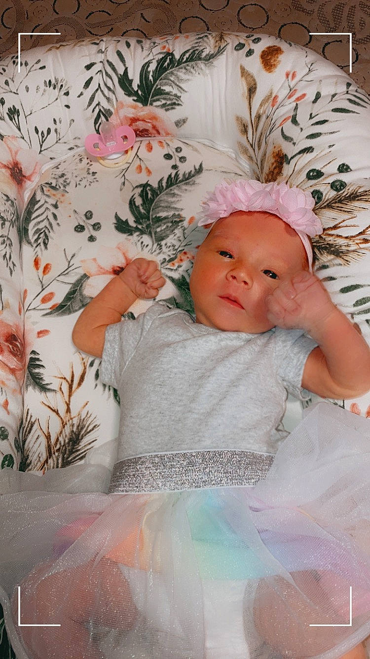 Oaklyn joined the competition — help win amazing prizes! art, baby, baby_toddler_clothing, cap, child, comfort, fashion_accessory, grass, happy, linens, pattern, peach, person, petal, pink, plant, room, skin, sleeve, textile