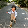 Ethan a rejoint le concours — aidez-le/la à gagner de superbes lots ! child, curly_hair, cute, daylight, greenery, happy, nature, outdoor, overalls, pathway, person, playful, shadow, shoes, smiling, sunlight, toddler, trees, urban, walking