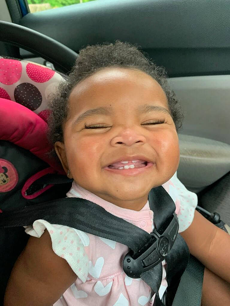 Kaliyah is registered to the contest to win money with this photo: auto_part, automotive_design, automotive_exterior, car, car_seat, child, eyebrow, finger, fun, gesture, happy, head_restraint, joy, motor_vehicle, nose, person, skin, smile, thumb, toddler
