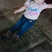 Paisley is registered to the contest to win money with this photo: baby, child, girl, jeans, shirt, headband, bow, couch, furniture, indoor, casual_clothing, footwear, boots, infant, person, relaxing, side_view, curious, home, seated