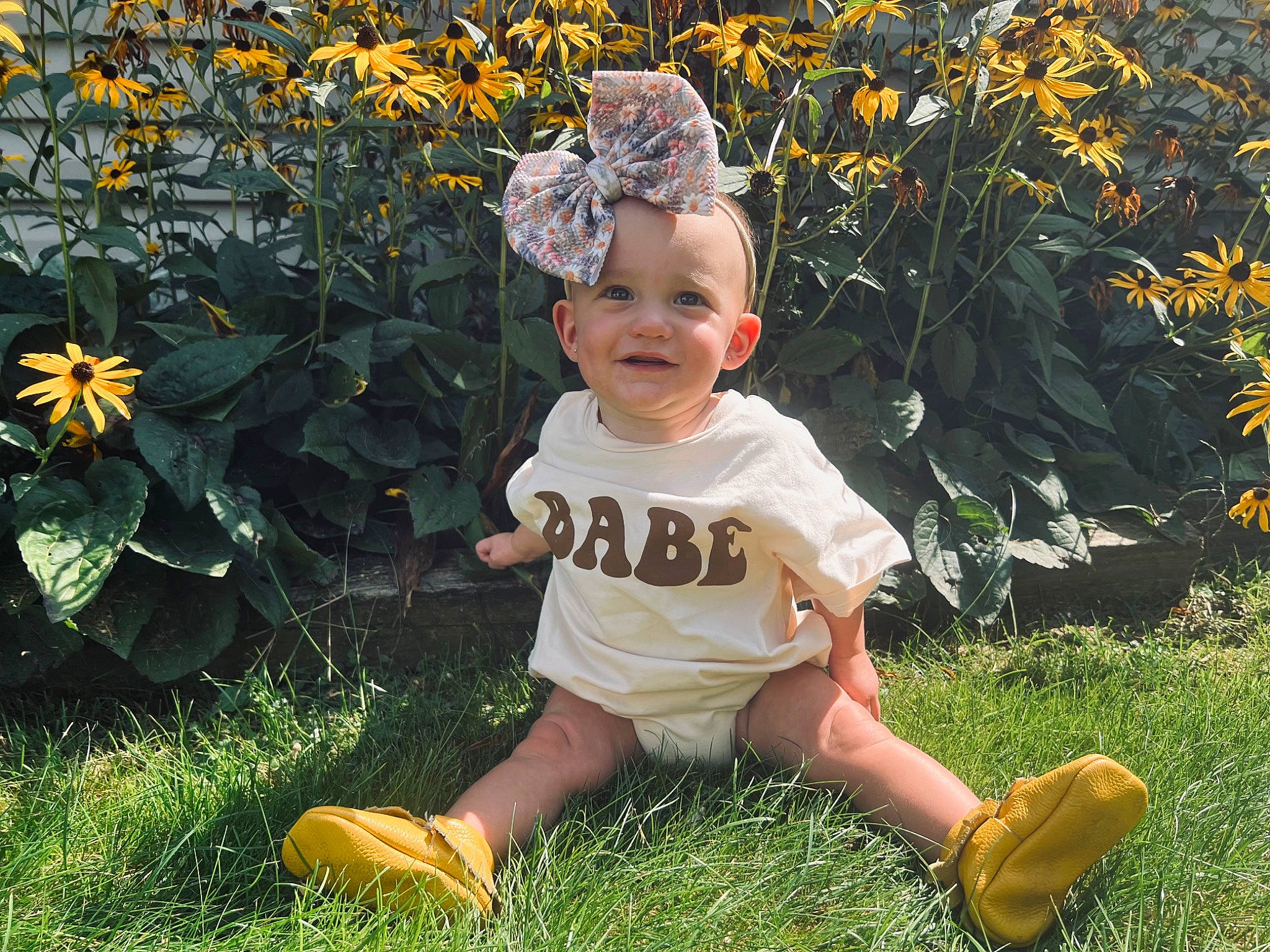 Dixie is registered to the contest to win money with this photo: baby_toddler_clothing, child, cool, flower, fun, grass, grass_family, happy, headwear, joy, lawn, meadow, natural_environment, people_in_nature, person, petal, plant, sleeve, smile, summer