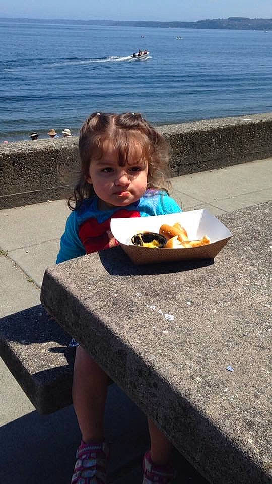 Hananiah is registered to the contest to win money with this photo: baby, child, eating, event, food, fun, grass, happy, human_leg, leisure, person, plate, recreation, sandal, sitting, summer, tableware, thigh, toddler, travel