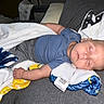 Elijah is registered to the contest to win money with this photo: baby, sleeping, infant, child, portrait, couch, blanket, blue_clothing, gray_clothing, plush_blanket, indoor, home, relaxed, peaceful, resting, lying_down, closed_eyes, face, soft_furnishings, photography