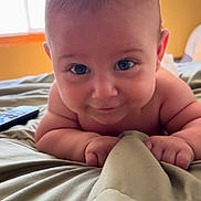 Elijah joined the competition — help win amazing prizes! baby, infant, face, eyes, hands, blanket, bed, remote_control, skin, room, window, light, curious, lying_down, closeup, child, indoors, soft_light, cute, portrait