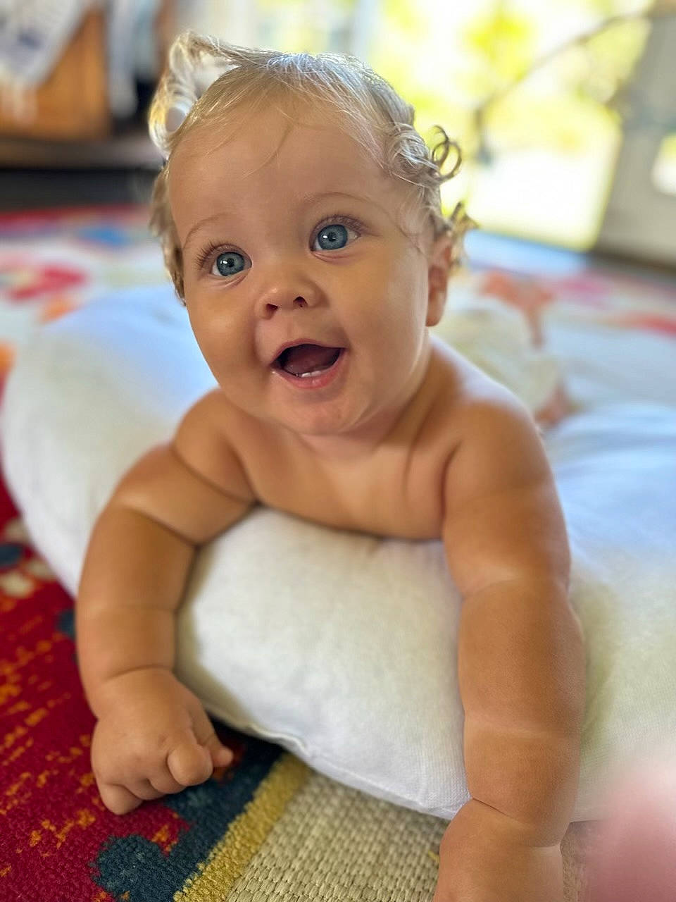 Titus is registered to the contest to win money with this photo: arm, baby, cheek, chest, child, chin, comfort, eye, face, flooring, fun, happy, human_body, iris, leisure, linens, person, sitting, skin, smile