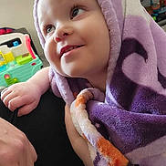 Mckensey is registered to the contest to win money with this photo: toddler, child, blanket, purple, smiling, face, indoor, toy, playroom, happy, person, cozy, closeup, infant, cute, soft, wrapped, baby, expression, young