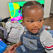 Royal joined the competition — help win amazing prizes! toddler, child, denim_overalls, indoor, television, colorful_screen, pigtails, person, clothing, hand, floor, furniture, curious, skin, hair, holding, seated, background, room, casual