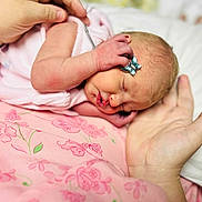 Kaylynn is registered to the contest to win money with this photo: newborn, baby, infant, sleeping, hand, pink, butterfly_clip, closeup, skin, soft, fabric, floral_pattern, peaceful, cute, resting, tiny, adult_hand, bed, blanket, portrait