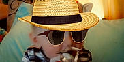 Jay is registered to the contest to win money with this photo: baby, blanket, child, curtains, cushion, cute, face, green_toy, hands, hat, indoor, mustache, playful, plush, portrait, sitting, soft_lighting, striped_shirt, stuffed_toy, sunglasses