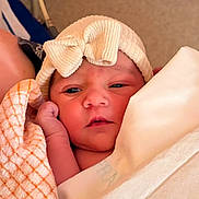 Maïa participe au concours pour gagner de l'argent avec cette photo : baby, newborn, infant, blanket, hat, bow, wrapped, closeup, face, skin, hand, cute, sleepy, soft, warm, indoors, person, portrait, resting, cozy