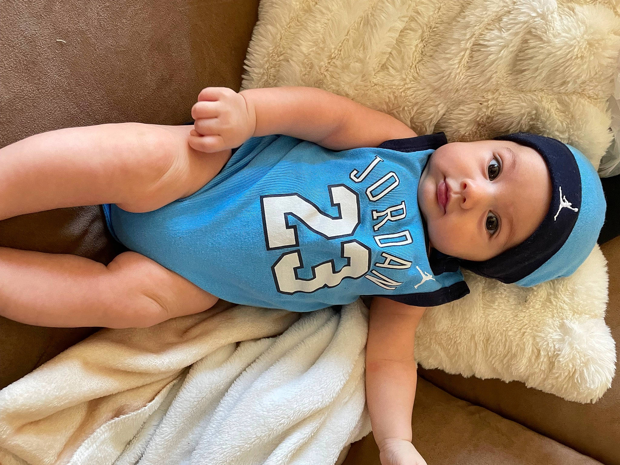 Isaiah is registered to the contest to win money with this photo: arm, azure, baby_toddler_clothing, comfort, cool, elbow, electric_blue, eye, happy, head, headwear, human_body, human_leg, joint, knee, leg, neck, person, skin, sleeve