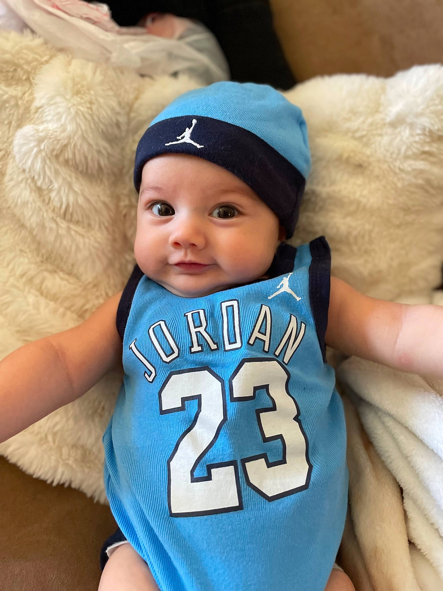 Isaiah is registered to the contest to win money with this photo: arm, azure, baby, baby_toddler_clothing, cap, eye, face, facial_expression, finger, fun, gesture, happy, head, headwear, mammal, person, photograph, skin, textile, toddler