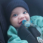 Koceila a rejoint le concours — aidez-le/la à gagner de superbes lots ! adorable, baby, baby_clothes, blue_eyes, car_seat, child, child_safety, closeup, cute, face, green_clothing, happy, hat, indoor, infant, knit_hat, pacifier, seatbelt, smiling, young_child