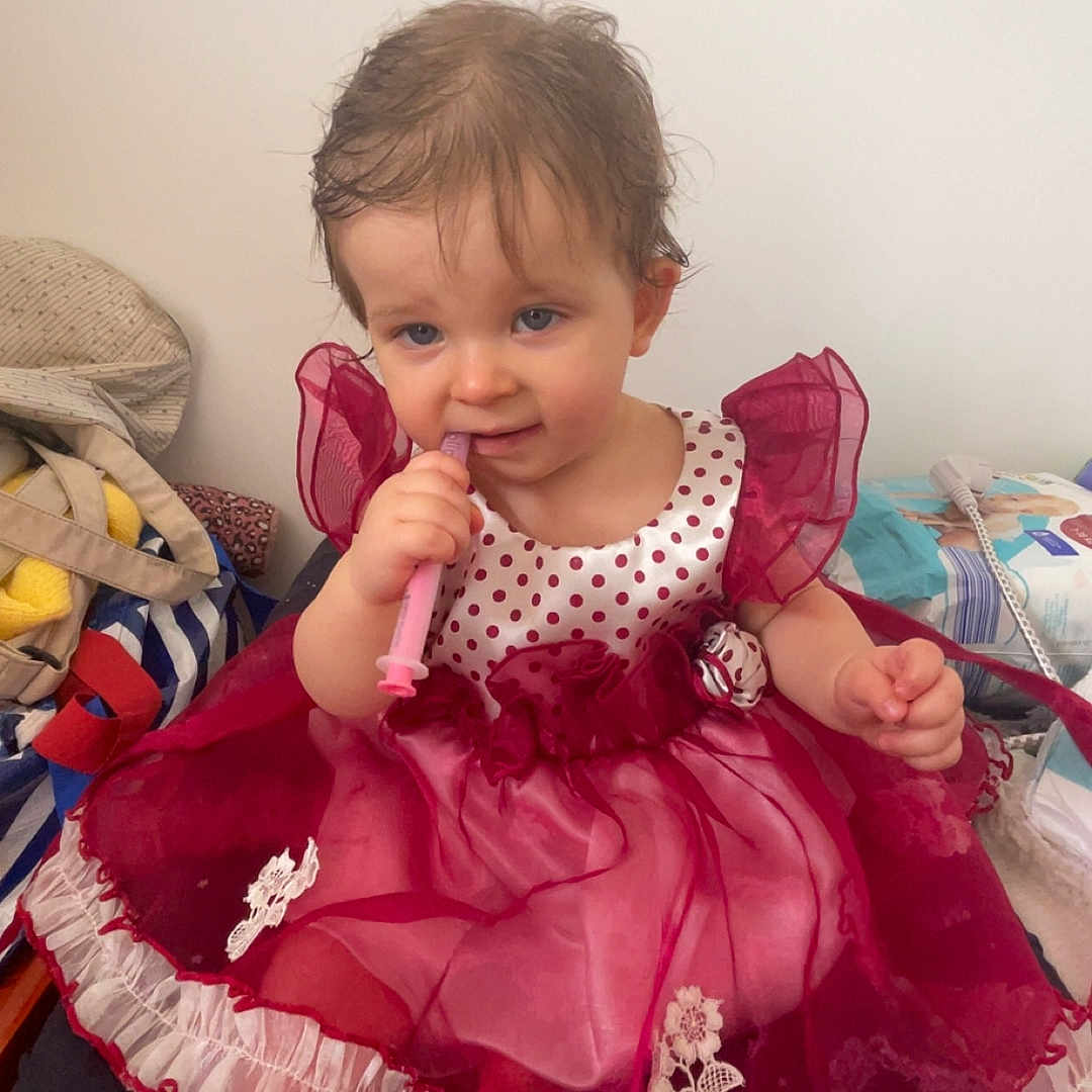 Mahyna a rejoint le concours — aidez-le/la à gagner de superbes lots ! blanket, chewing, child, dress, fabric, face, foot, furniture, hair, home, indoor, pattern, person, polka_dots, red, sitting, syringe, toddler, toy, white