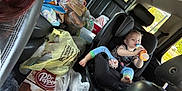 Drake is registered to the contest to win money with this photo: black_leather_seats, bottle, car_interior, car_seat, casual, child, dr_pepper, drink, foot, grocery_bags, hair, partial_face, person, plastic_bags, red_hair, road_trip, seatbelt, snacks, toddler, window