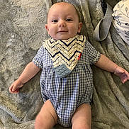 Beckett is registered to the contest to win money with this photo: arm, baby, bib, blanket, blue, child, clothing, cute, fabric, face, happy, indoor, infant, leg, lying_down, onesie, pattern, skin, smile, soft_texture