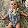 arm, baby, bib, blanket, blue, child, clothing, cute, fabric, face, happy, indoor, infant, leg, lying_down, onesie, pattern, skin, smile, soft_texture