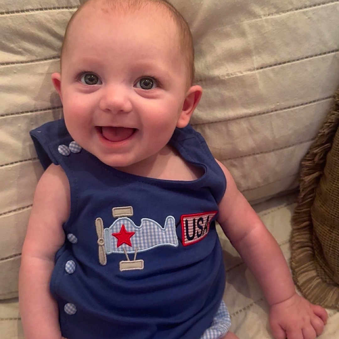 Beckett joined the competition — help win amazing prizes! baby, blue_clothing, buttoned_clothing, child, couch, cute, face, happy, indoors, infant, patch, person, playful, portrait, quilted_cushion, short_sleeves, sitting, skin, smile, young_child
