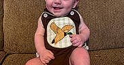 Beckett is registered to the contest to win money with this photo: baby, brown, child, couch, cute, duck, embroidery, face, furniture, happy, head, indoors, infant, legs, onesie, person, portrait, sitting, skin, smiling