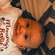 Oakley Wheeler joined the competition — help win amazing prizes! baby, infant, child, portrait, smiling, lying_down, blanket, bed, indoor, cozy, patterned, clothing, embroidered_shirt, long_sleeves, face, eyes, head, happy, close_up, photography