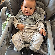 Tony participe au concours pour gagner de l'argent avec cette photo : baby, child, smiling, high_chair, clothing, nike_logo, socks, blanket, indoor, person, cute, comfortable, gray, seat, happy, portrait, infant, young_child, baby_clothes, footwear