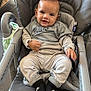 baby, child, smiling, high_chair, clothing, nike_logo, socks, blanket, indoor, person, cute, comfortable, gray, seat, happy, portrait, infant, young_child, baby_clothes, footwear