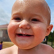 Judd is registered to the contest to win money with this photo: baby, child, smiling, face, water_droplets, head, outdoor, sunlight, skin, expression, happy, closeup, portrait, cheeks, eyes, mouth, teeth, nature, daylight, background