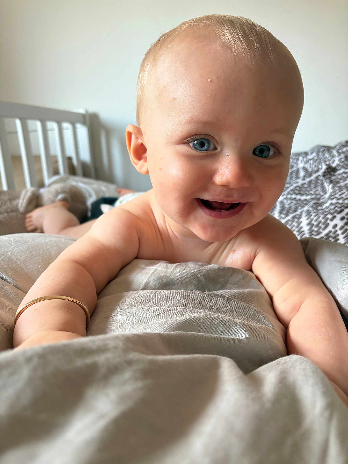 Negan a rejoint le concours — aidez-le/la à gagner de superbes lots ! baby, child, smiling, blue_eyes, bracelet, blanket, crib, stuffed_toy, happy, skin, closeup, bedroom, infant, person, portrait, indoor, cute, toddler, soft_light, expression