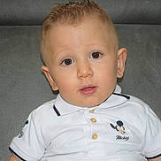 Marvin Bailleul participe au concours pour gagner de l'argent avec cette photo : child, toddler, boy, face, eyes, hair, shirt, mickey_mouse, polo_shirt, white_clothing, couch, gray_background, indoor, portrait, cute, young, sitting, looking_at_camera, casual, expression