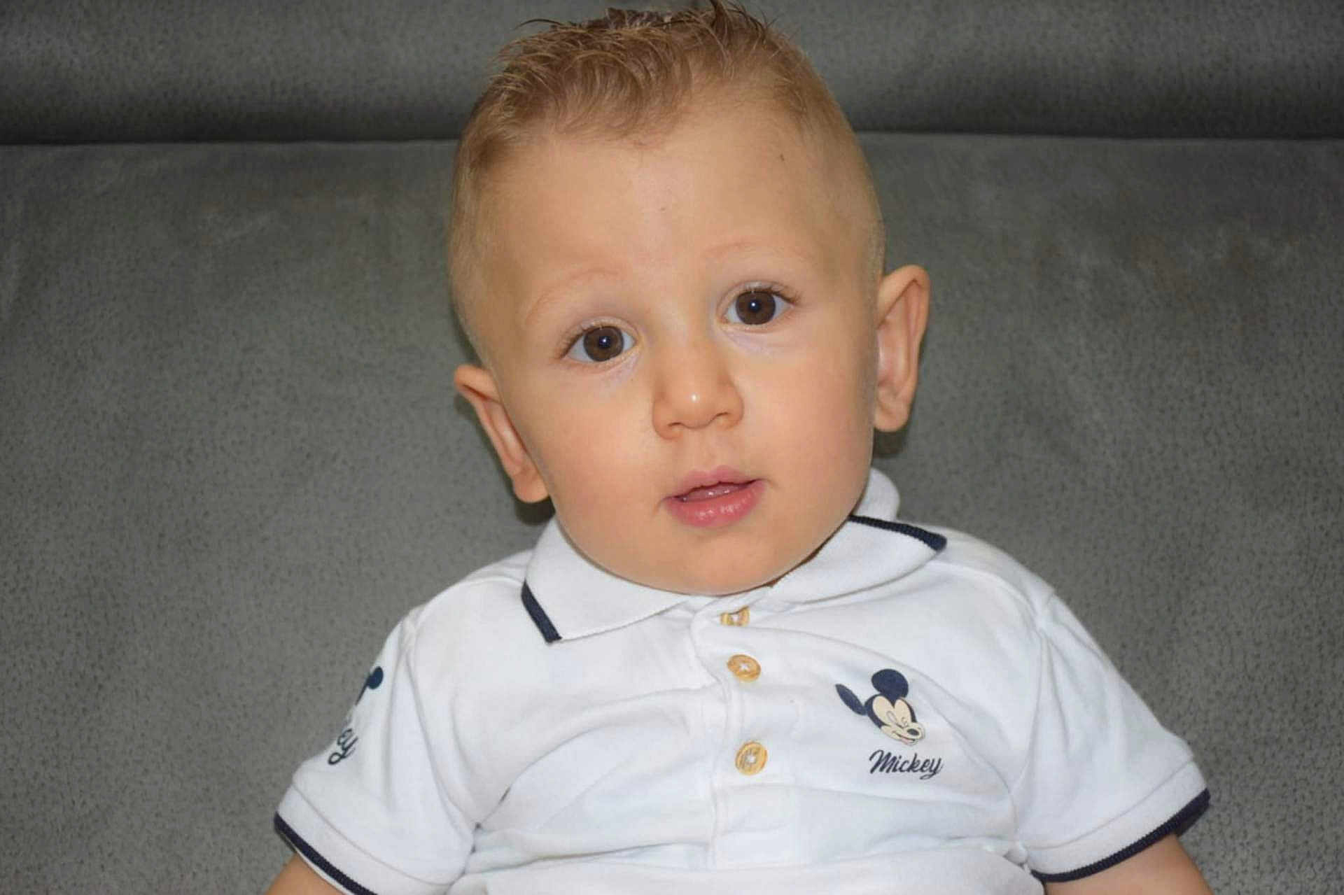 Marvin Bailleul participe au concours pour gagner de l'argent avec cette photo : child, toddler, boy, face, eyes, hair, shirt, mickey_mouse, polo_shirt, white_clothing, couch, gray_background, indoor, portrait, cute, young, sitting, looking_at_camera, casual, expression
