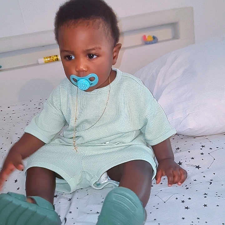 Mahel a rejoint le concours — aidez-le/la à gagner de superbes lots ! baby, bed, bedspread, casual, child, cute, decor, furniture, indoor, mint_green_clothing, necklace, pacifier, person, portrait, shoes, sitting, sleeping_area, star_pattern, toddler, young_child