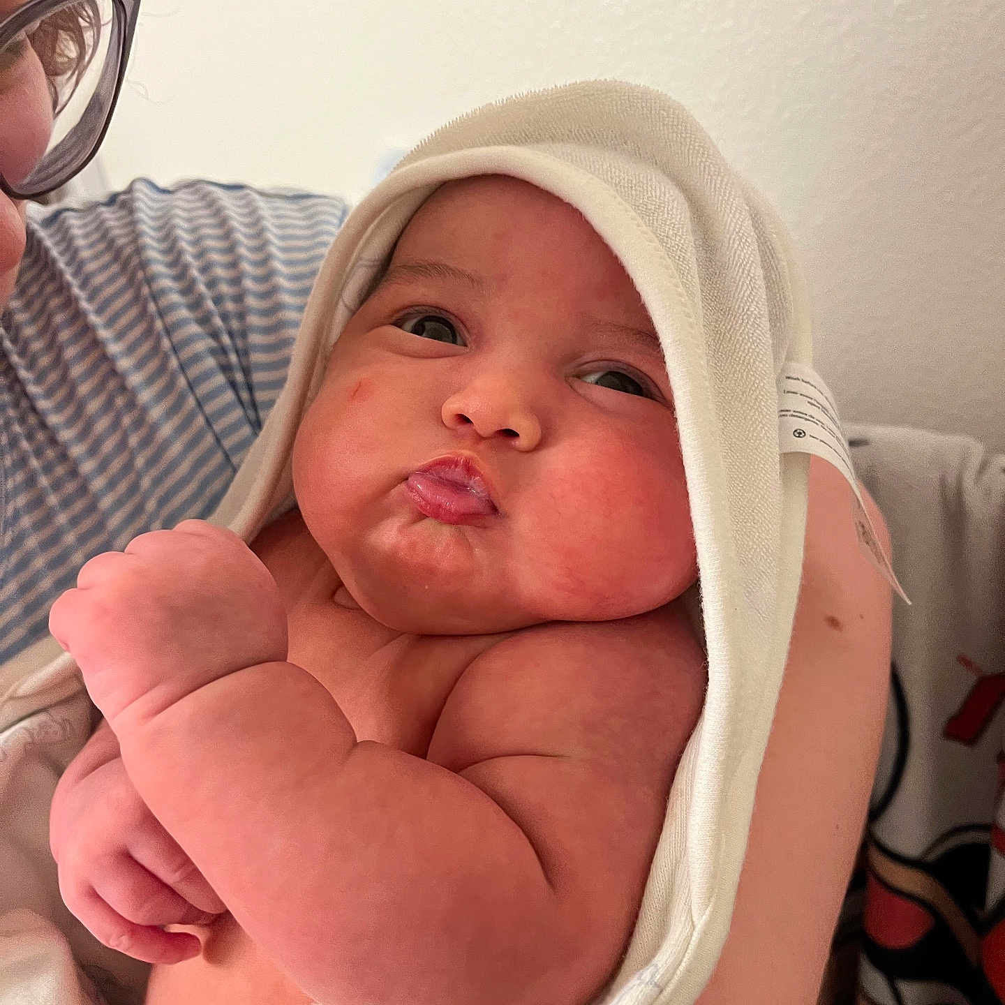 Oliver is registered to the contest to win money with this photo: arm, baby, bath_time, closeup, cute, expression, face, glasses, hand, holding, indoor, infant, love, newborn, parent, person, pout, skin, striped_shirt, towel