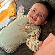 Lucas participe au concours pour gagner de l'argent avec cette photo : baby, blanket, blue_eyes, cheeks, couch, cozy, fabric, face, hair, hand, happy, indoor, infant, onesie, patterned_clothing, playful, portrait, smiling, sofa, toddler