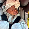 Alani Faith Vidal is registered to the contest to win money with this photo: newborn, baby, sleeping, infant, car_seat, safety_harness, headband, bow, blanket, knitted_clothing, mittens, bundled, portrait, close_up, indoors, vehicle, passenger, peaceful, cute, warning_label