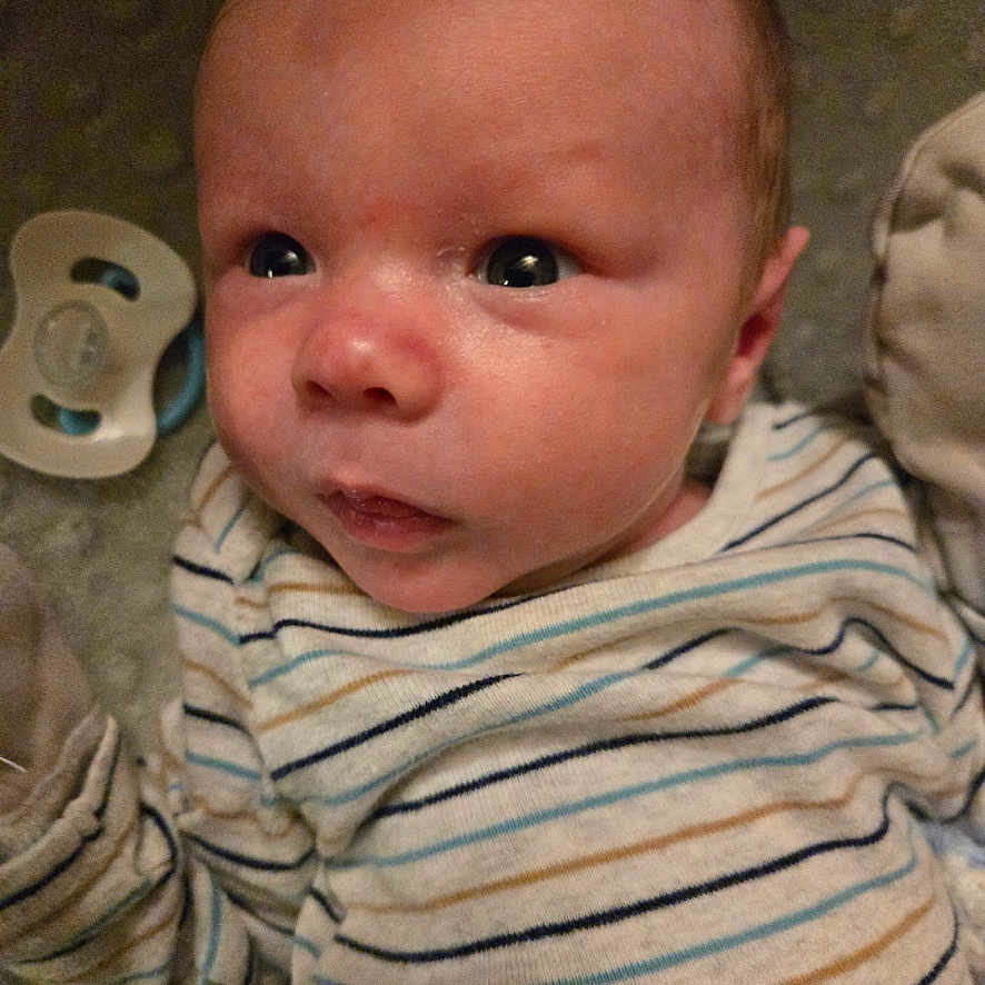 Kayden is registered to the contest to win money with this photo: accessories, baby, bodypart, clothing, couch, face, finger, furniture, hand, happy, head, mouth, newborn, person, photography, portrait, selfie, shirt, sitting, smile