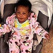 Chloe joined the competition — help win amazing prizes! baby, child, car_seat, pink_clothing, fleece, mickey_mouse_pattern, indoor, smile, happy, cute, infant, seatbelt, car_seat_strap, person, young_child, plush, cozy, carrying_device, carpet, portrait