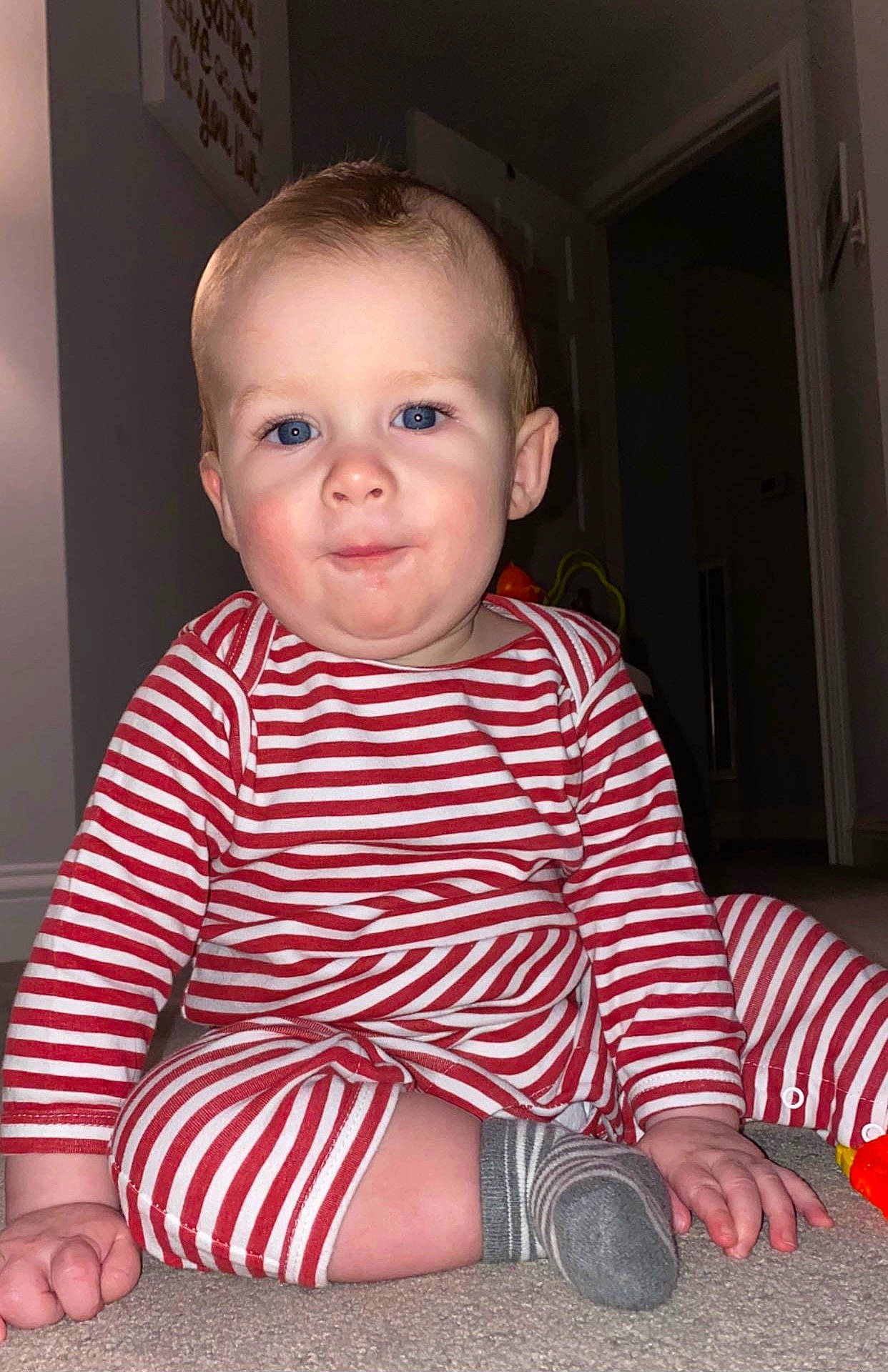 Beckham is registered to the contest to win money with this photo: baby, baby_toddler_clothing, beauty, carmine, cheek, child, comfort, dress_shirt, face, flooring, pattern, person, sitting, skin, sleeve, smile, standing, t_shirt, toddler, walking_shoe