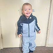 Ivar is registered to the contest to win money with this photo: boy, child, clothing, coat, door, face, formalwear, head, jacket, jeans, knitwear, male, pajamas, pants, person, photography, portrait, standing, suit, sweater