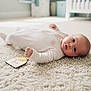 Maeve joined the competition — help win amazing prizes! baby, infant, carpet, floor, crib, nursery, onesie, child, indoors, soft, cute, lying_down, person, blue_eyes, pale_pink, cozy, home, newborn, baby_girl, portrait