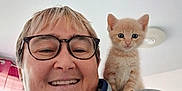 Lyra a rejoint le concours — aidez-le/la à gagner de superbes lots ! person, glasses, smile, kitten, cat, indoor, shoulder, jacket, scarf, window, curtain, light, face, pet, cute, animal, happy, feline, blond_hair, cozy