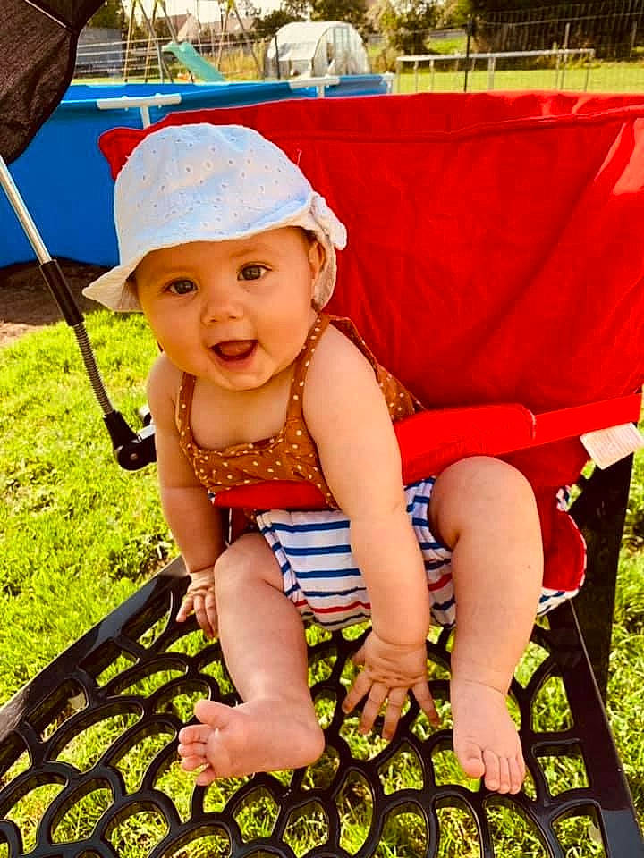 Lyana a rejoint le concours — aidez-le/la à gagner de superbes lots ! baby, baby_toddler_clothing, baseball_cap, chair, child, event, foot, fun, grass, happy, headwear, human_leg, leisure, people_in_nature, person, recreation, sandal, sitting, skin, smile