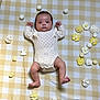 Iris a rejoint le concours — aidez-le/la à gagner de superbes lots ! baby, infant, knitwear, cream_color, lying_down, yellow, white, checkered_pattern, flowers, decorative_flowers, number_two, cute, soft_texture, blanket, raised_arms, bare_feet, indoors, portrait, child, adorable