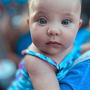 Emori is registered to the contest to win money with this photo: arm, baby, blue, child, closeup, clothing, curious, cute, expression, eyes, face, holding, human, infant, outdoor, person, portrait, skin, soft_background, young