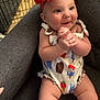 Emori is registered to the contest to win money with this photo: baby, child, clothing, couch, cute, expression, flower, furniture, hands, happy, headband, indoors, infant, legs, onesie, person, portrait, sitting, skin, smiling