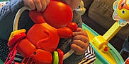 Emori joined the competition — help win amazing prizes! activity_center, baby, chewing, child, closeup, colorful, couch, curious, cushion, face, furniture, hand, home, indoor, infant, orange_toy, person, play, sitting, toy