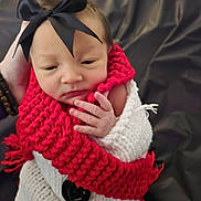 Bailynn Renea joined the competition — help win amazing prizes! baby, newborn, infant, bow, headband, red_scarf, knitted_scarf, white_blanket, wrapped, hand, fingers, face, sleepy, cozy, portrait, closeup, button, dark_background, bracelet, knitwear