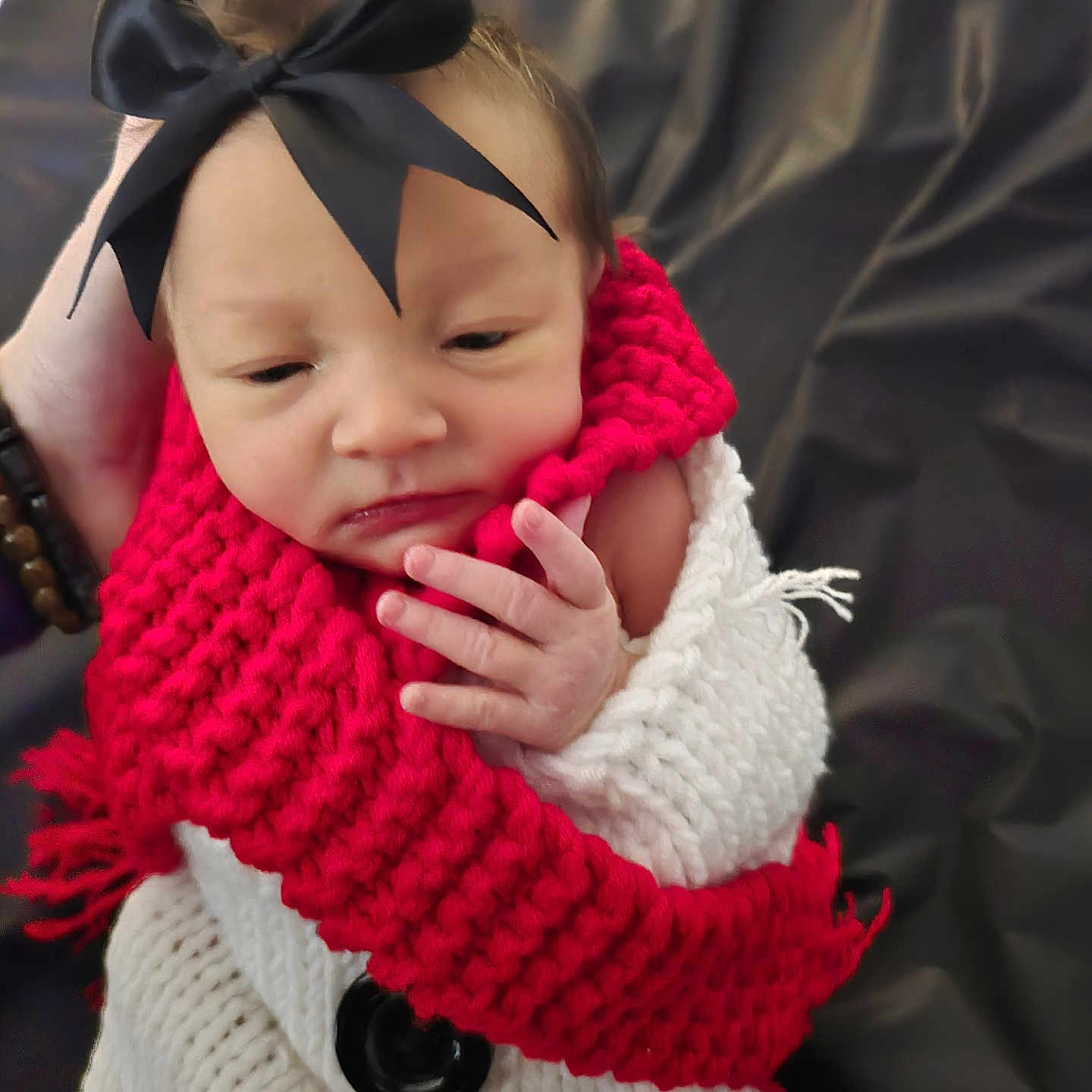 Bailynn Renea joined the competition — help win amazing prizes! baby, bow, bracelet, button, closeup, cozy, dark_background, face, fingers, hand, headband, infant, knitted_scarf, knitwear, newborn, portrait, red_scarf, sleepy, white_blanket, wrapped