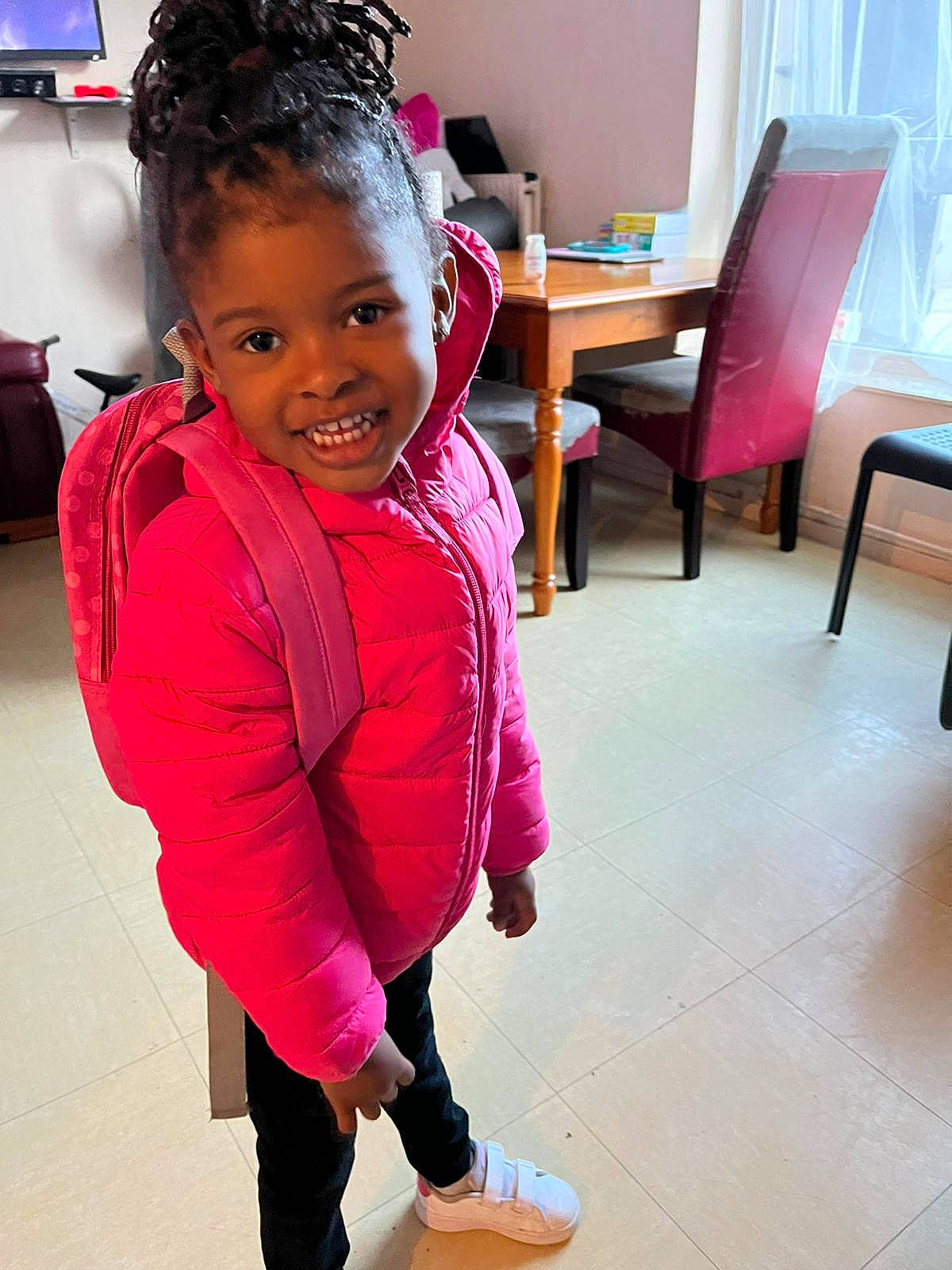 Assyah participe au concours pour gagner de l'argent avec cette photo : chair, child, curtain, fashion_accessory, floor, flooring, fun, happy, home_appliance, joy, leisure, magenta, person, room, sitting, skin, sleeve, smile, standing, table