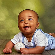 Kaisen is registered to the contest to win money with this photo: baby, infant, smiling, happy, baseball, toy, child, cute, portrait, tummy_time, clothing, white_shirt, blue_overalls, floor, wooden_floor, indoors, face, eyes, hands, expression